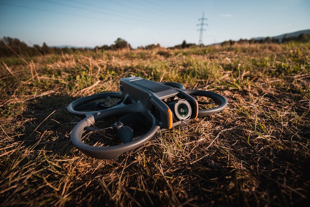 A close-up view of a drone resting on a grassy field, showcasing outdoor technology use.