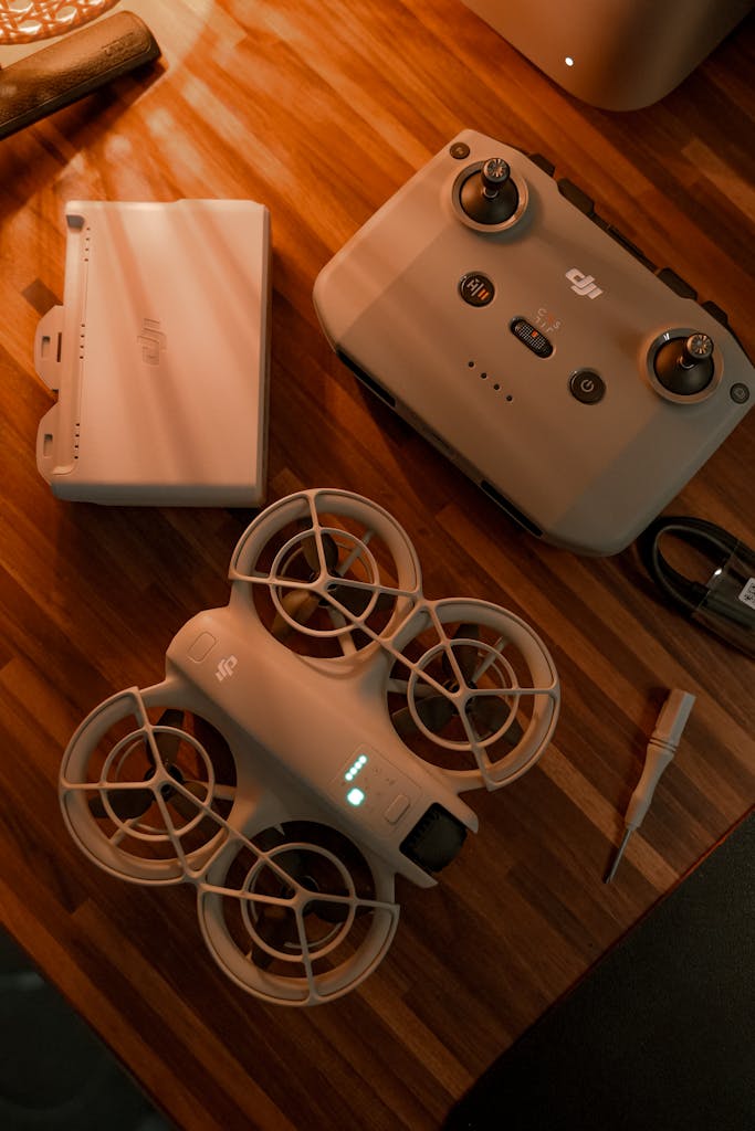 Top-down view of a DJI drone with remote on a wooden desk, showcasing tech accessories.