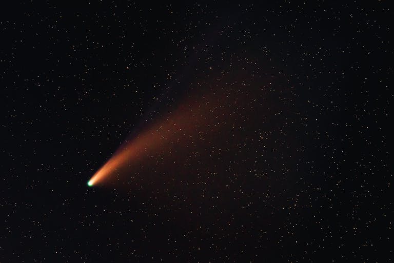 A vibrant comet with a glowing tail traversing the starry night sky, showcasing the wonders of the universe.