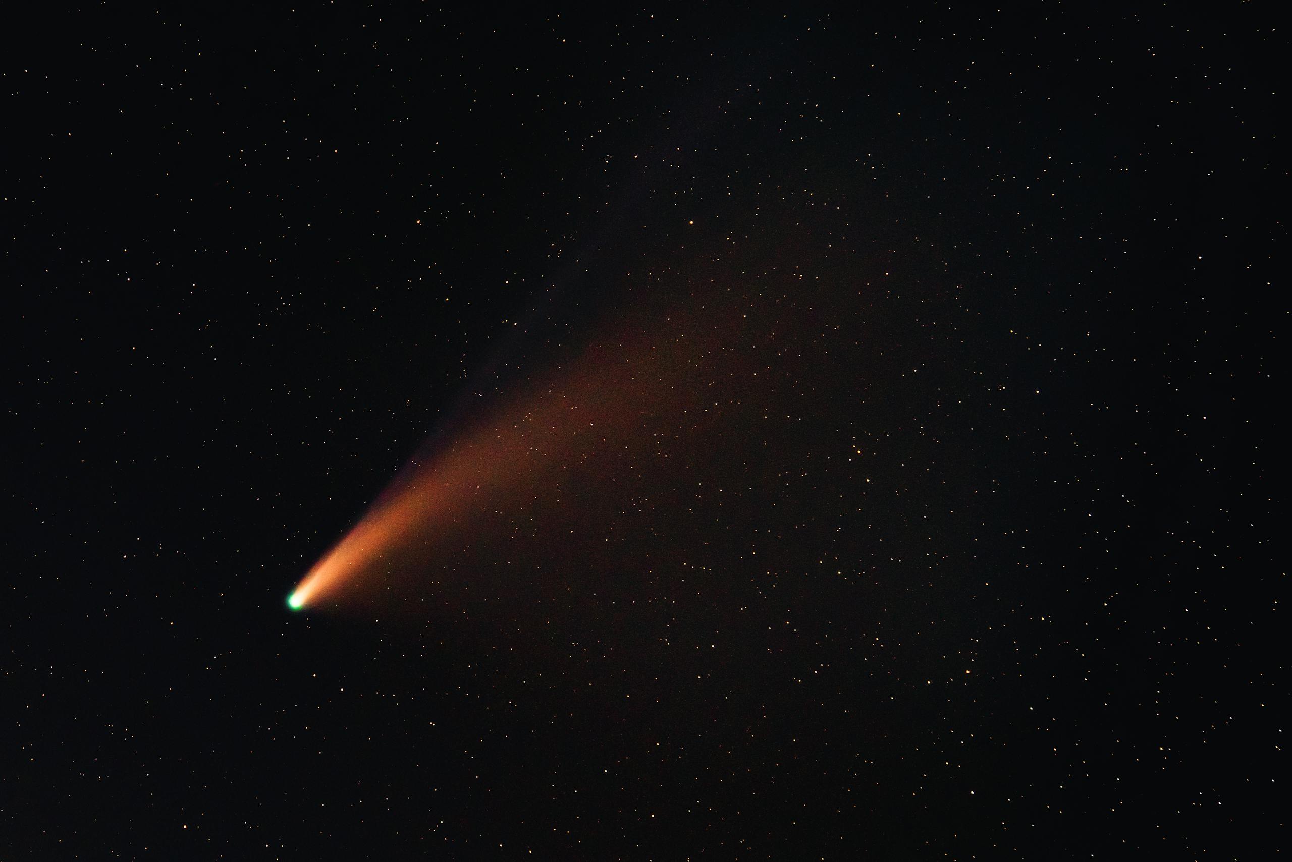 A vibrant comet with a glowing tail traversing the starry night sky, showcasing the wonders of the universe.