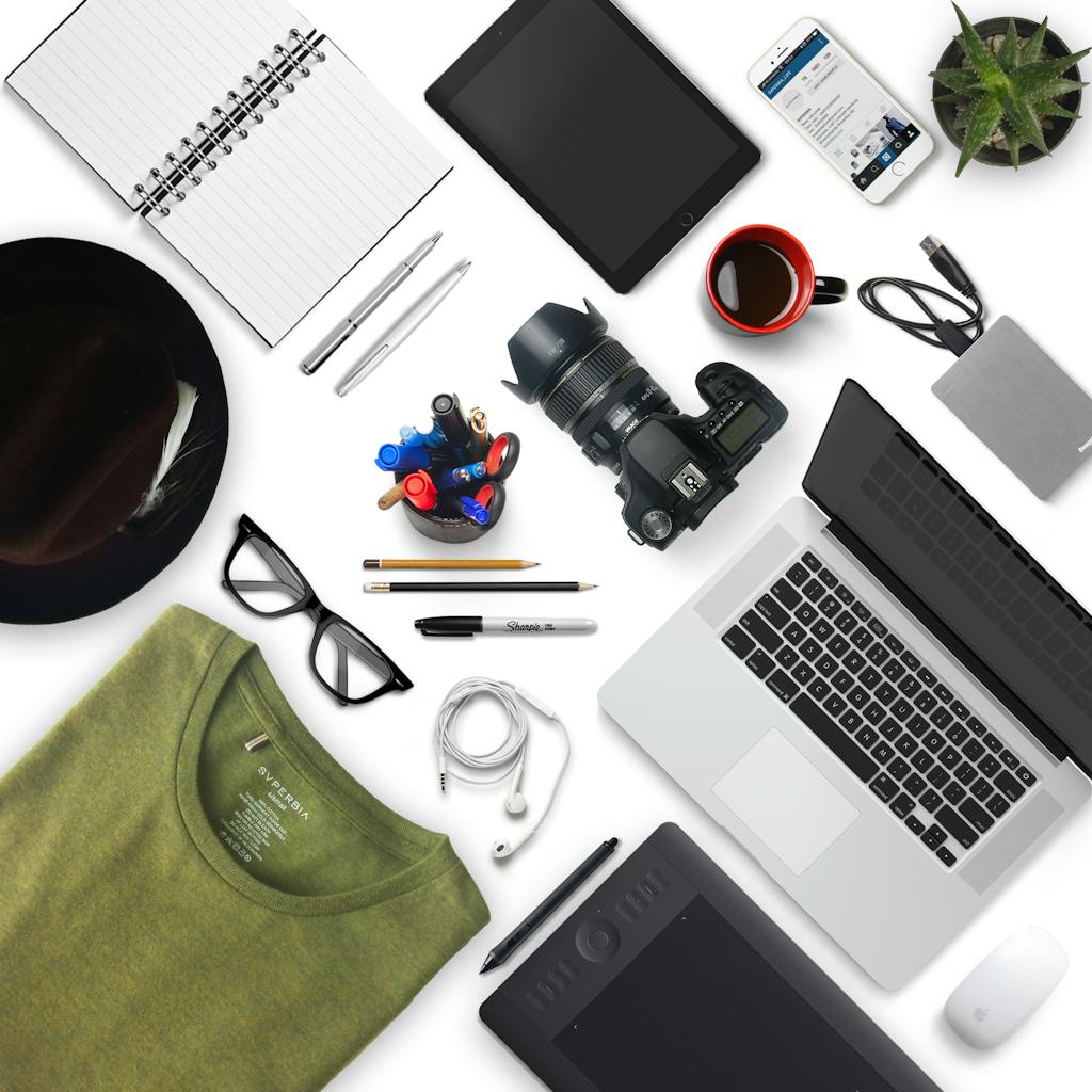 Top view of a creative workspace with camera, laptop, and accessories, perfect for a designer or photographer.